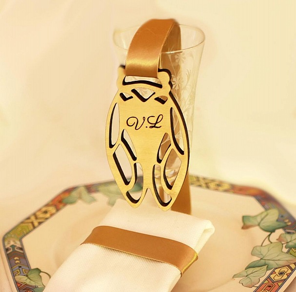 Marque-place cigale en bois personnalisé sur verre et serviette.