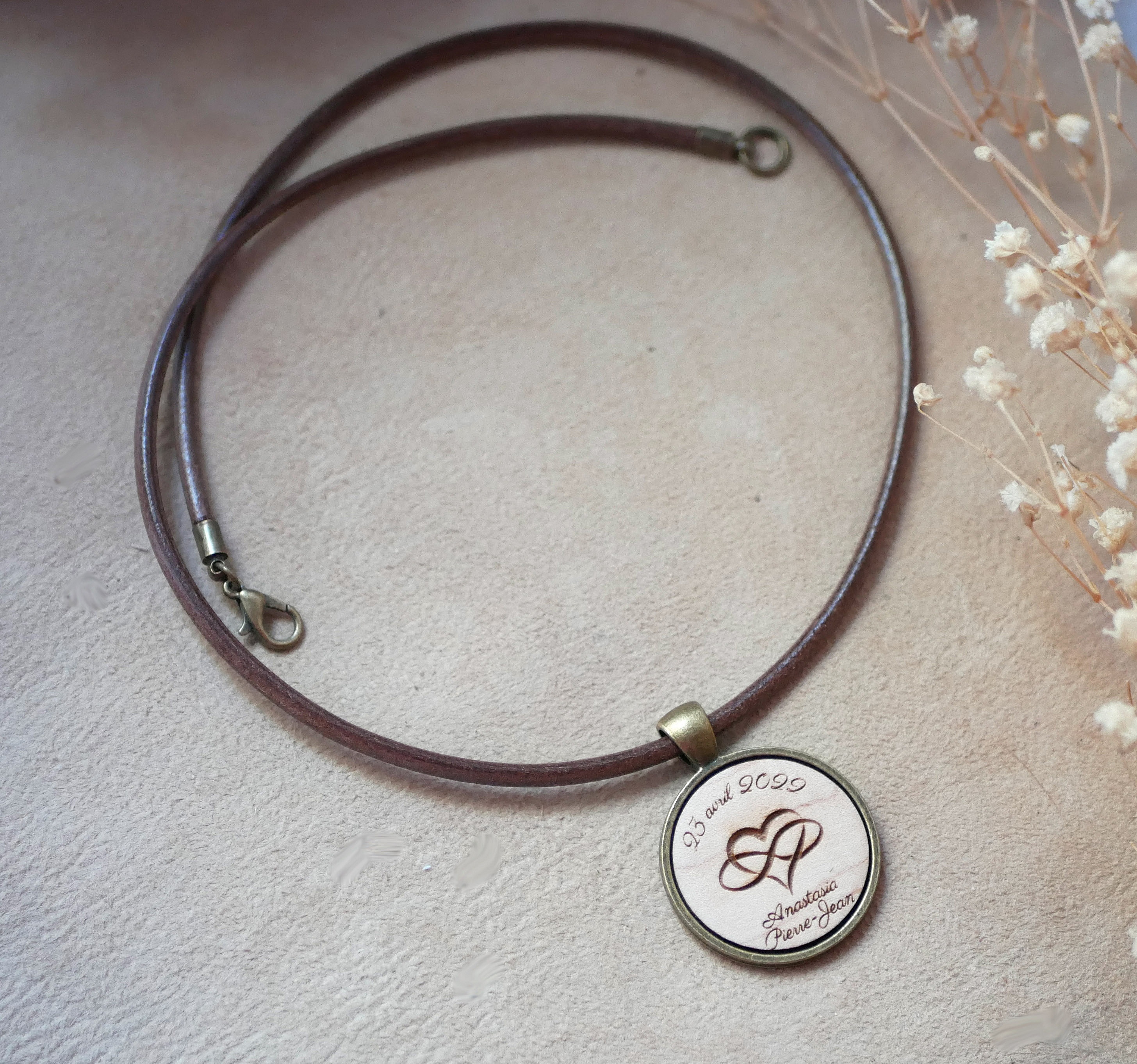Pendentif en bois gravé sur collier en cuir personnalisable.