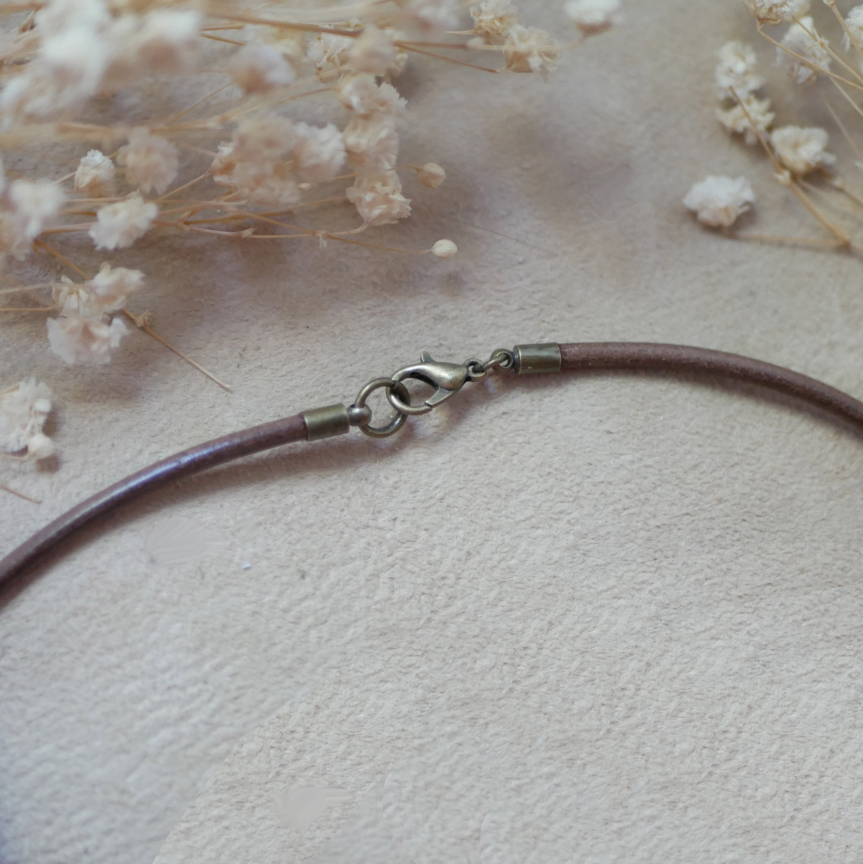 Fermoir de collier en cuir européen avec fleurs séchées.