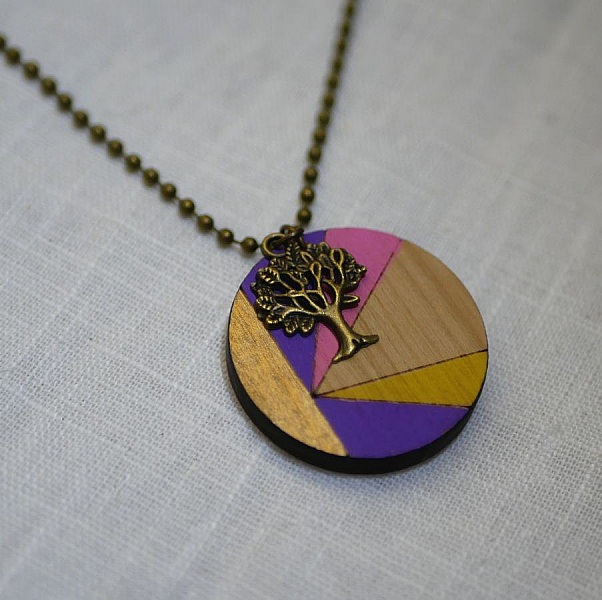 Pendentif rond en bois peint avec breloque arbre bronze.